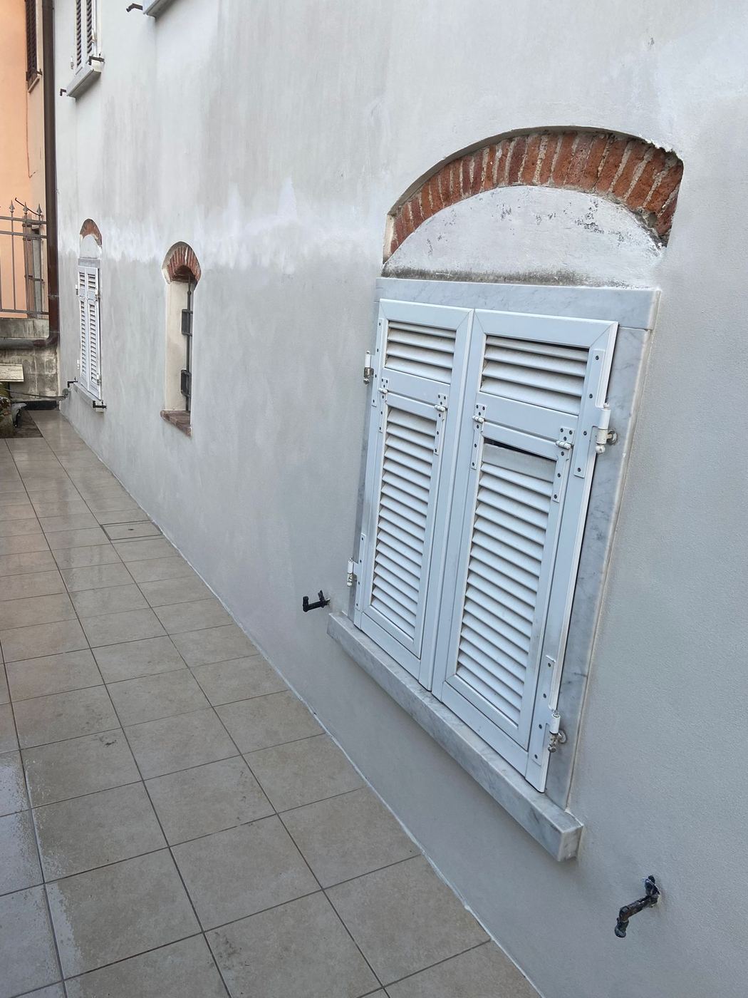 Dettaglio di finestra con cornice in marmo su facciata in fase di finitura